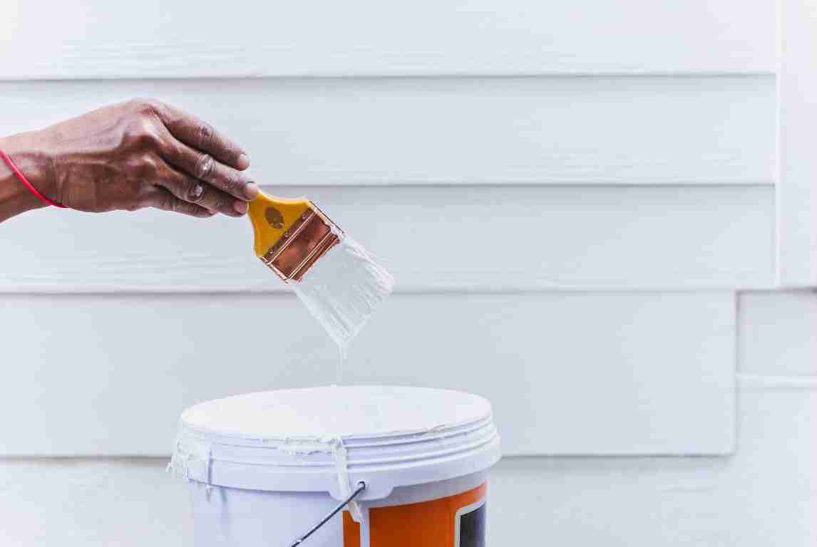 Professional painter painting a home exterior in Texas